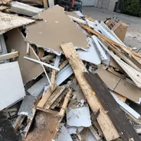 A pile of broken drywall, boards and trim