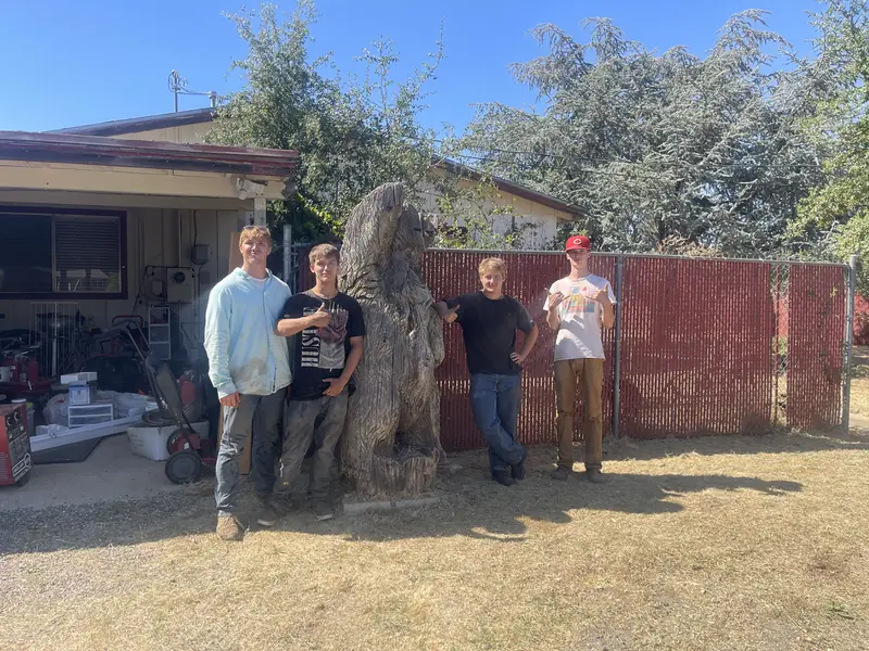 Four crew members standing together in front of a building