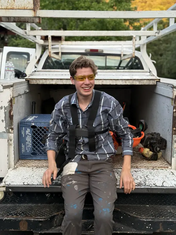 Levi Cones, owner of Tuolumne County Junk Removal, sitting on the tailgate of his work truck
